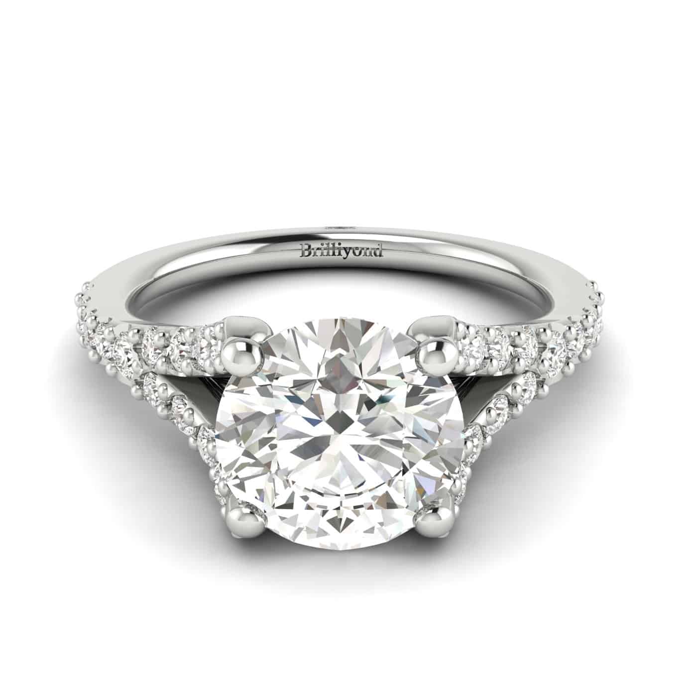 A four-pronged diamond engagement ring featuring 26 white cubic zirconia accent stones in pavé split shank setting.